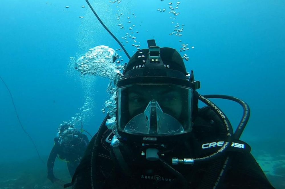 A diver in full gear, descending into the depths of the ocean