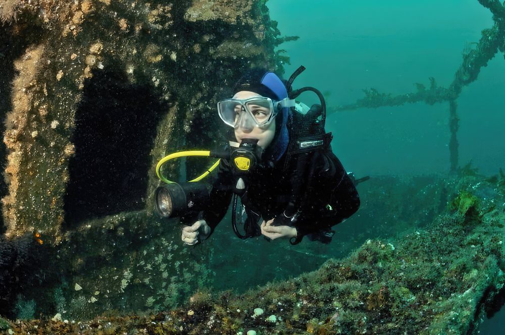 A diver navigating the Ex HMAS Adelaide wreck