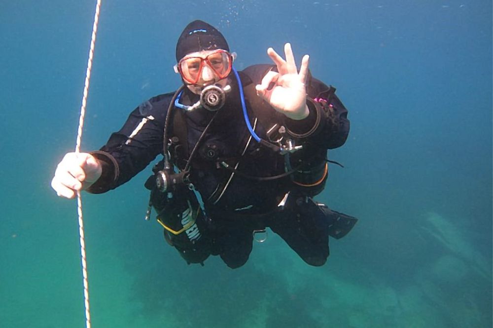 Scuba divers following safety tips for boat diving by following the line to the bottom