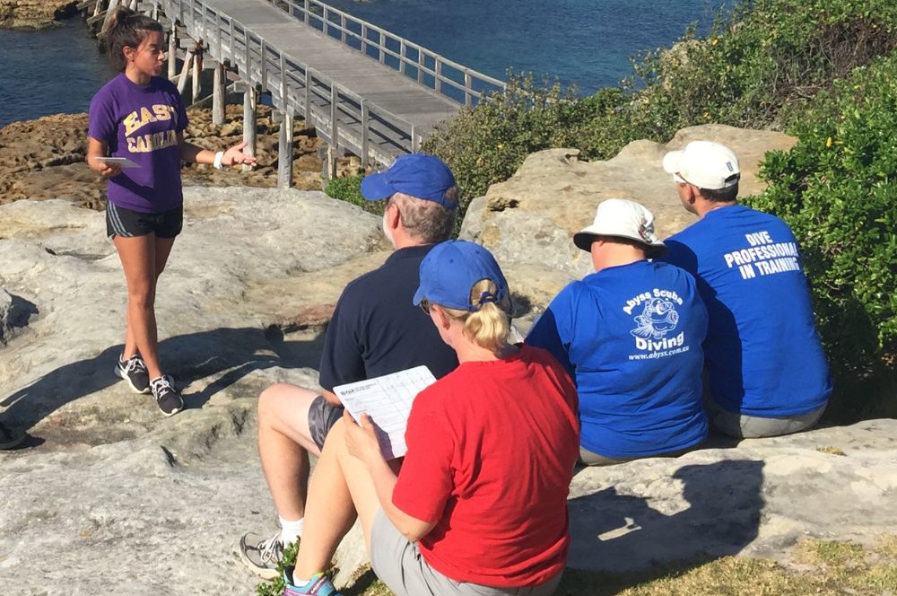 Divers learning how to give a dive briefing as part of thier divemaster course