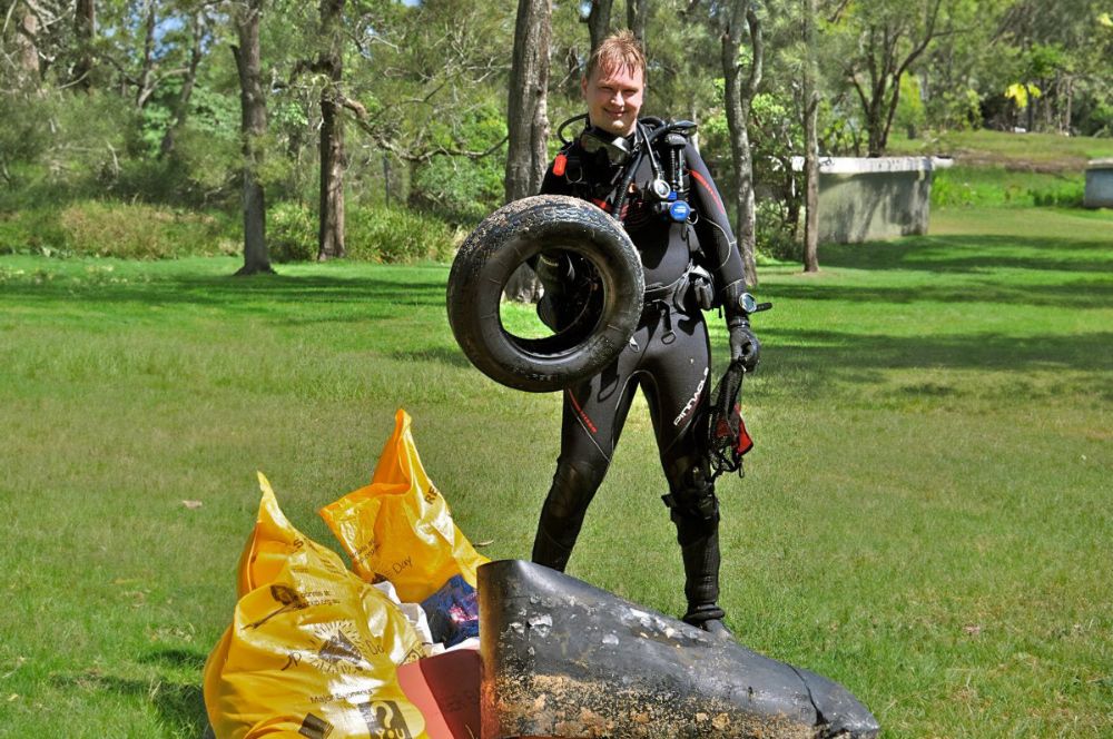 Scuba divers with rubish from his dive against debris