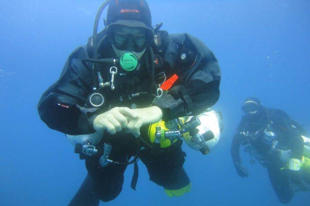 Scuba diver in a drysuit at depth with peak buoyancy control