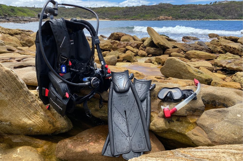 A full set of scuba diving gear on the shore line