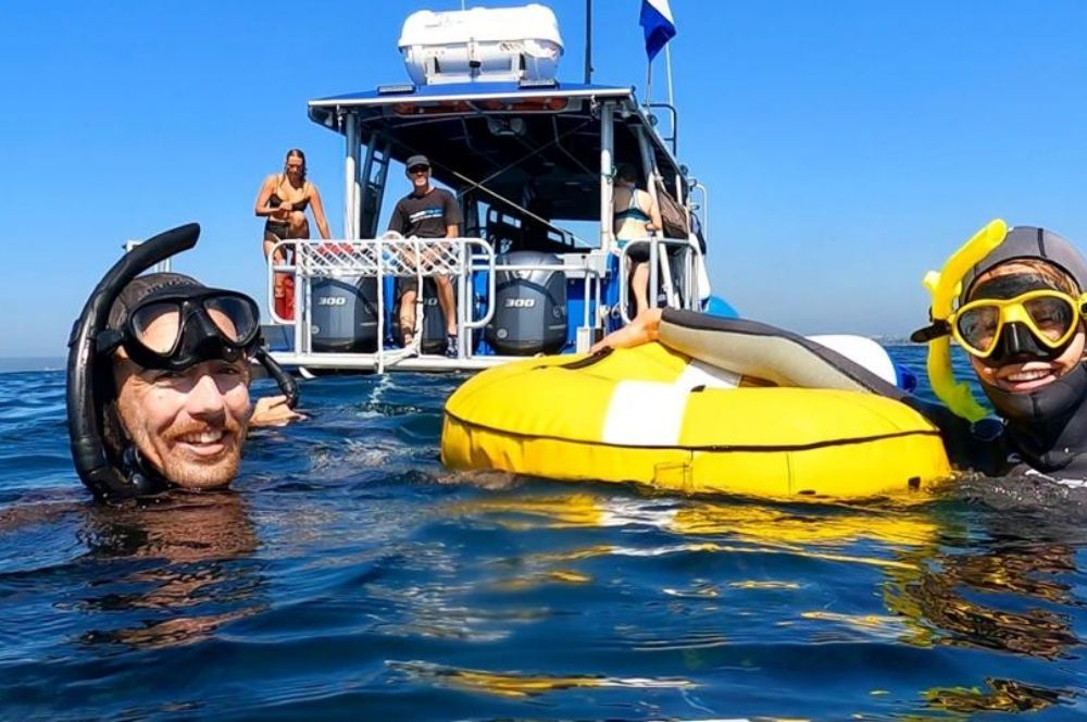 A person freediving in the ocean, following safety procedures