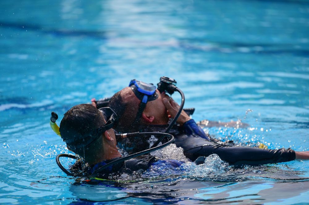A diver in a wet suit and scuba gear, practicing rescue scenarios