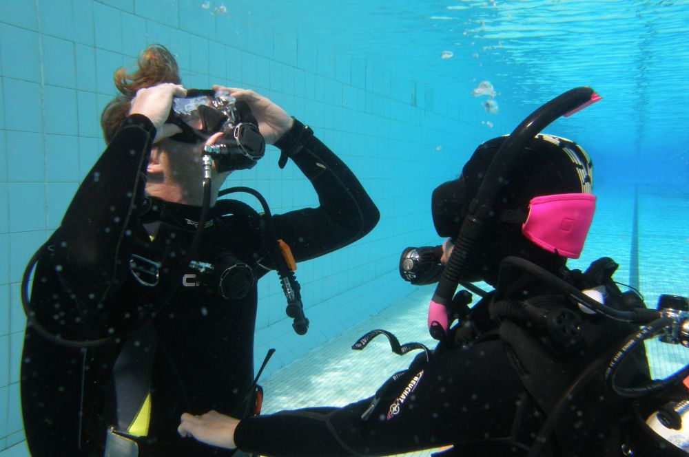 A scuba diver at the pooll, practicing scuba refresher course skills