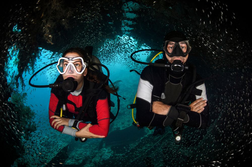 A buddy pair of experienced diver wearing a buoyancy compensator and achieving unparalleled buoyancy control in the underwater world