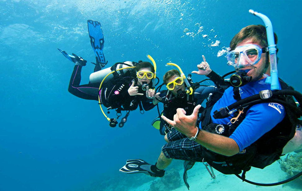 Scuba diver in the ocean with dive school and instructor