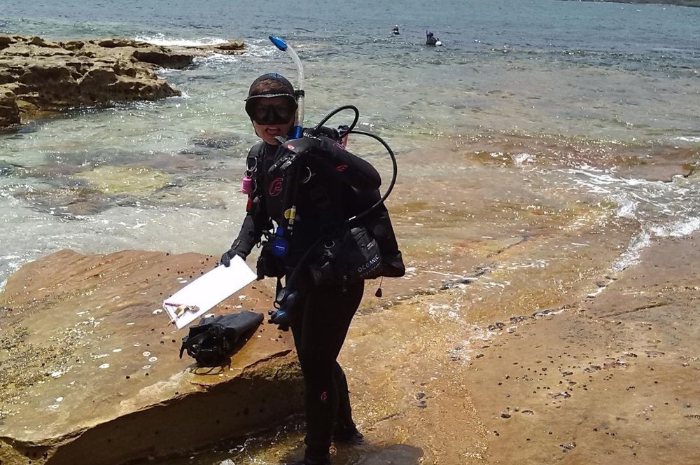 A scuba diver practicing responsible scuba diving ethics by not touching or disturbing marine life while conducting scientific research as a citizen scientist.