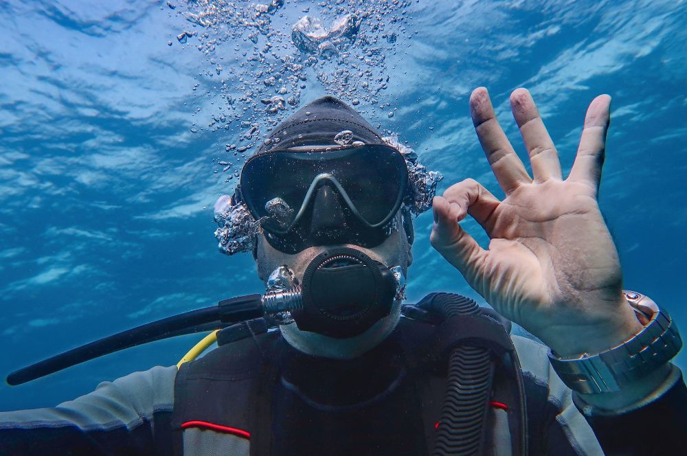 Scuba divers choosing and communicating with dive buddy