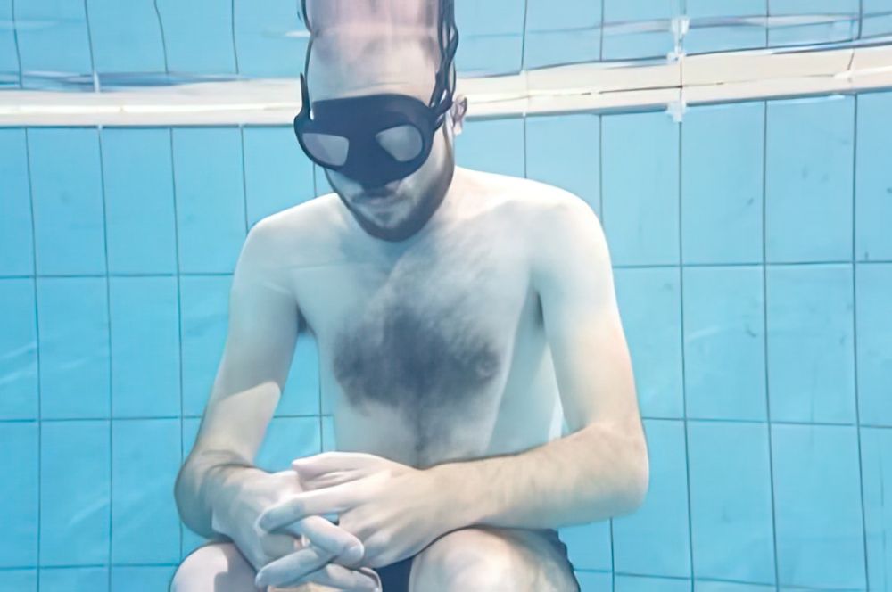 A freediver practicing breathing techniques to prepare for a dive