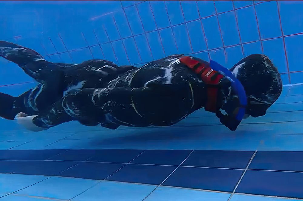 A hreediver wearing a weight belt and neck weights to achieve netral buoyancy while freediving