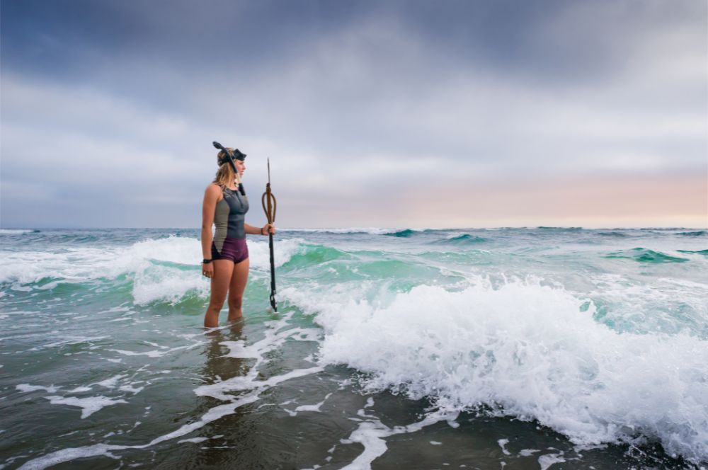 A spearfisher checking strong surf while coastal spearfishing